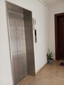 a sliding glass door in a room with a plant at Guest Room Near Airport in Ariana