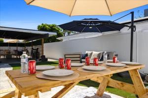 einem Holztisch mit Tellern und einem Regenschirm in der Unterkunft Modern Unique Charming Memorable Clean 1g Wifi in Bakersfield