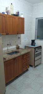 a kitchen with a sink and a stove at Praia, Laser, Comércio in Praia Grande