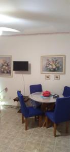 a dining room with a table and blue chairs at Praia, Laser, Comércio in Praia Grande