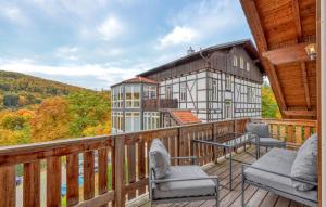 a balcony with chairs and a house in the background at Amazing Apartment In Südharz With Sauna in Stolberg i. Harz +27 photos