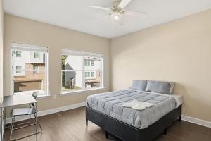 Sunny AcresModern Comfort and Resort Style Living Near CU的一间卧室配有一张带吊扇和窗户的床。 更多18张照片