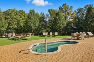 Sunny AcresModern Comfort and Resort Style Living Near CU的公园内的游泳池,配有桌椅