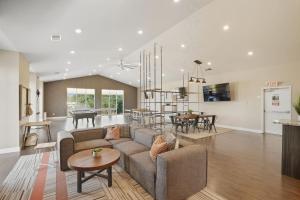 Sunny AcresModern Comfort and Resort Style Living Near CU的客厅兼厨房，配有沙发和桌子。