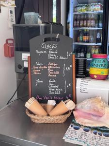 a chalkboard sign with some hot dogs in a basket at Karibbean Resort in Sainte-Luce