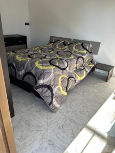 a bed with a black and yellow comforter at Très bel appartement spacieux in Taza