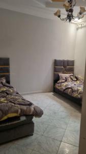 a room with two beds and a chandelier at Très bel appartement spacieux in Taza