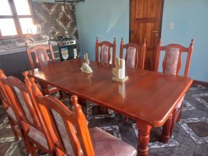 a dining room table with chairs and a wooden table at Casa de familia in Cachí +16 photos