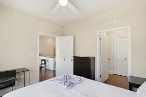 a white bedroom with a bed and a desk at Relax and Explore Poolside Stay Near Local Spots in Sunny Acres