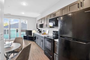 a kitchen with a stainless steel refrigerator and a table at Stylish Downtown Escape Near IU and Cafes in Bloomington