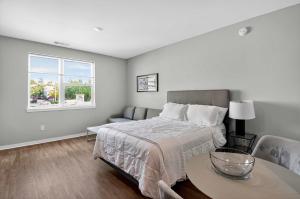 Un dormitorio con una cama y una mesa y una ventana. en Stylish Downtown Escape Near IU and Cafes, en Bloomington