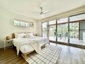 een slaapkamer met een bed en een groot raam bij Ocean Aura Room A in Airlie Beach