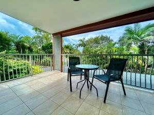 een terras met twee stoelen en een tafel op een balkon bij Ocean Aura Room A in Airlie Beach
