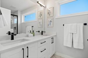 ein weißes Bad mit 2 Waschbecken und einem Fenster in der Unterkunft 2 in 1 Modern Retreat 4BR House Private Lower Suite in Calgary