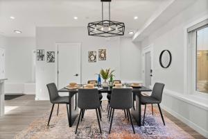 ein Esszimmer mit einem schwarzen Tisch und Stühlen in der Unterkunft 2 in 1 Modern Retreat 4BR House Private Lower Suite in Calgary + 38 Fotos