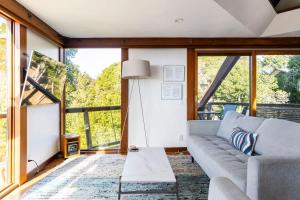 a living room with a couch and a table at Peaceful Treehouse with Ocean View in Cliftwood Mobile Home Park