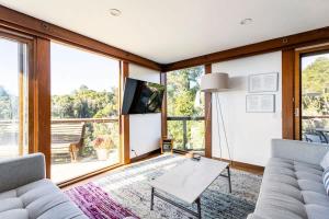 a living room with a couch and a table at Peaceful Treehouse with Ocean View in Cliftwood Mobile Home Park
