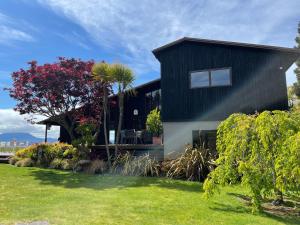 una casa con techo negro en Stunning panoramic Lakeview , spa pool & privacy, en Taupo 5 fotos más