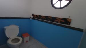 a bathroom with a toilet and a clock on the wall at Ninho da Águia - Chalés in Poços de Caldas