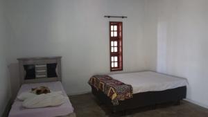 a bedroom with two beds and a dog laying on a pillow at Ninho da Águia - Chalés in Poços de Caldas