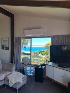 a living room with a couch and a large window at Turanga Heights in Gisborne