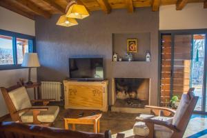 a living room with a fireplace and a tv at Casa Isolina in Ciudad Lujan de Cuyo