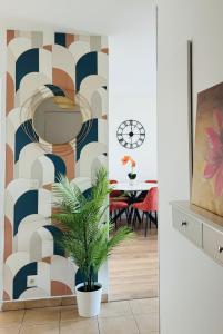a dining room with a wall mural and a plant at Canal de Yvette in Longjumeau