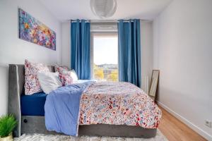 a bedroom with a bed with blue curtains and a window at Canal de Yvette in Longjumeau +4 photos