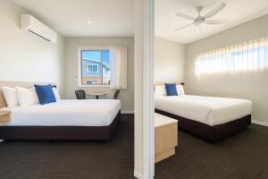 a hotel room with two beds and a window at Avenue WEST Studio Units in Toowoomba