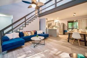a living room with a blue couch and a staircase at 4BD Cabin in the Poconos Near Lake with Hot Tub, Sauna, Game Room and Movie Room in East Stroudsburg