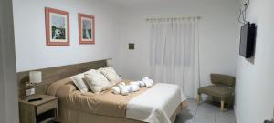 ein Schlafzimmer mit einem Bett mit zwei Stofftieren darauf in der Unterkunft CasaMar in General Villegas