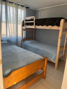 two bunk beds in a room with a window at Cabañitas Zelada en un ambiente natural con piscina fogón Quincho Terraza parking full equipadas en 5000 mtrs in Algarrobo +162 photos