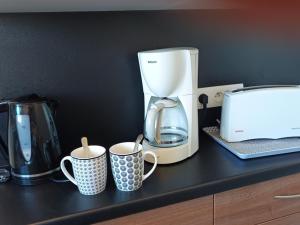 a coffee maker and two coffee cups on a counter at Notre-Dame-de-Monts (85) - Appartement de vacances 50m² environ - 4 personnes - FR-1-540-204 in Notre-Dame-de-Monts