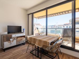 a dining room with a table and a large window at Grand Studio Rénové, Balcon, Centre-Ville Arcachon, à 50m de la Plage, Tout Équipé - FR-1-319-516 in Arcachon