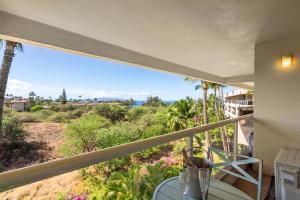 a balcony with a view of the desert and palm trees at Oceanview King Studio - Maui Banyan, Walk to Beach in Wailea