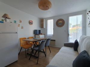 a kitchen and living room with a table and a couch at Maisonnette confortable proche plage, 4 pers, parking privé - FR-1-476-203 in La Faute-sur-Mer