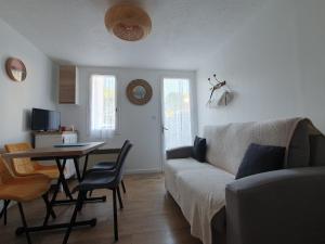 a living room with a couch and a table at Maisonnette confortable proche plage, 4 pers, parking privé - FR-1-476-203 in La Faute-sur-Mer +3 photos
