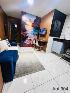 a living room with a blue couch and a piano at Studio luxuoso a 700 metros da praia. Vila Velha ES in Vila Velha