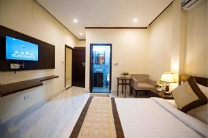 een hotelkamer met een bed en een tv bij Vang Vieng BON Boutique Hotel in Vang Vieng