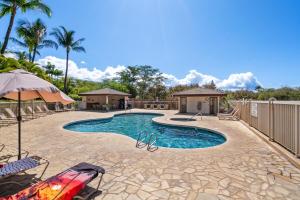 a swimming pool with chairs and an umbrella at Oceanview King Studio - Maui Banyan, Walk to Beach in Wailea