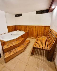 a bath room with a tub and two benches at Hotel Blumig in Villa General Belgrano
