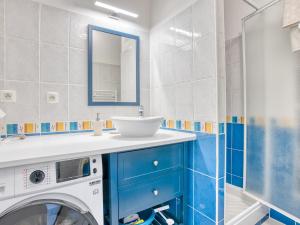 a bathroom with a washing machine and a sink at Charmant T2 avec terrasse, climatisation et WIFI - Quartier résidentiel à Biscarrosse - FR-1-521-217 in Biscarrosse +2 photos