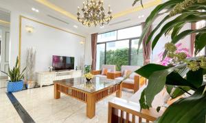 a living room with a table and some plants at Phoenix Villas FLC Ha Long in Ha Long