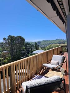 a balcony with two chairs on a wooden deck at Turanga Heights in Gisborne