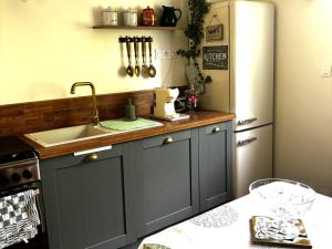 a kitchen with a sink and a refrigerator at Chambre d'Hôtes Charmante à Montargis - FR-1-590-573 in Montargis