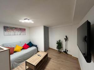 a living room with a couch with colorful pillows at Duplex T3 à La Bourboule - Proche thermes, 6 pers - FR-1-608-296 in La Bourboule