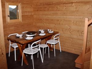 een eetkamer met een houten tafel en stoelen bij Chalet neuf pour 6 pers, animaux et parking - FR-1-836-36 in Arâches-la-Frasse