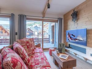 a living room with a couch and a flat screen tv at Appartement skis aux pieds avec 8 couchages à l'Alpe d'Huez - FR-1-645-96 in L'Alpe-d'Huez