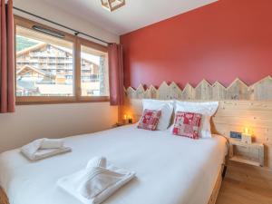 a bedroom with a large white bed with red walls at Appartement skis aux pieds avec 8 couchages à l'Alpe d'Huez - FR-1-645-96 in L'Alpe-d'Huez