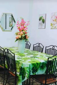 een eettafel met een vaas met bloemen erop bij Del Mar Residence 1 in Suizo
